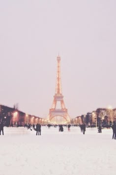 the eiffel tower is lit up in the snow