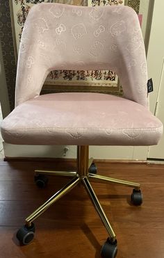 a pink chair sitting on top of a wooden floor