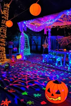 an outdoor halloween party with lights and pumpkins on the ground in front of a gazebo