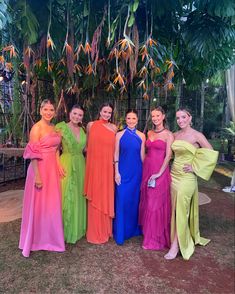 six women in colorful dresses posing for the camera