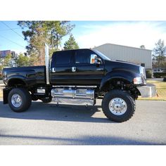 a large black truck parked in a parking lot