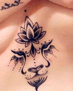 a woman's chest with a tattoo on it and flowers in the shape of a flower