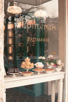 a window display with cakes and pastries in it