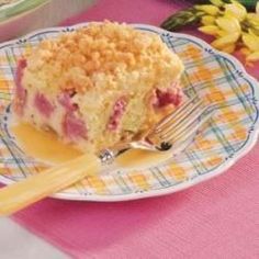 a close up of a piece of cake on a plate with a fork and flowers in the background