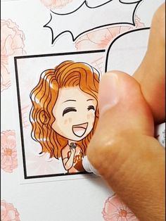 a person holding up a sticker with a drawing of a woman's face on it