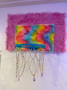 a multicolored purse with chains hanging from it's side on a wall