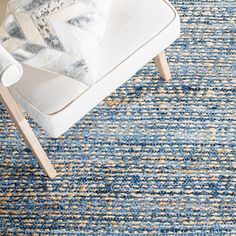 a blue and yellow rug with a white chair