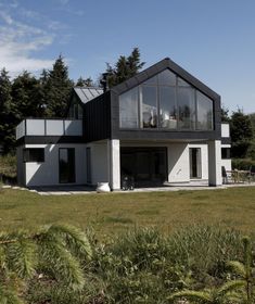 a large house sitting on top of a lush green field next to trees and grass