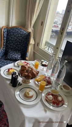 a table topped with plates of food next to a window