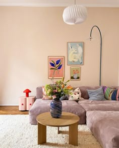 a living room filled with lots of furniture next to a wall mounted painting on the wall