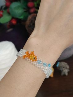 a woman's arm with a bracelet made out of beads and glass beads on it