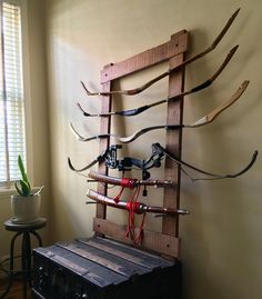 an old wooden ladder with many different types of arrows attached to it, in front of a window