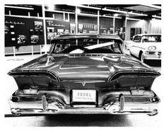 an old black and white photo of the back end of a car in a garage