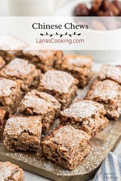 chinese chews on a cutting board with powdered sugar and raisins in the background