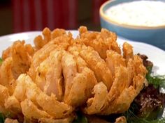 a white plate topped with fried food on top of lettuce