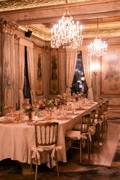 an elegant dining room with chandelier and table set for two people to eat