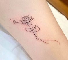 a woman's leg with a flower tattoo on her left arm and the word love written in cursive writing