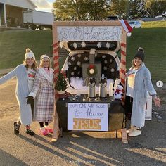 three girls are standing in front of a truck decorated for christmas with decorations on it