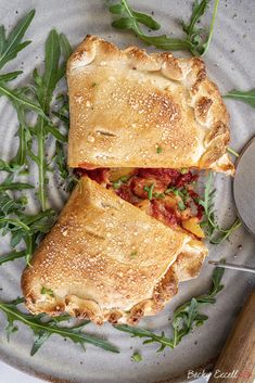 two slices of pizza sitting on top of a plate next to a knife and fork