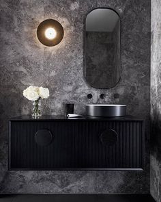 a black and white bathroom with marble walls