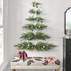 a small christmas tree is hanging on the wall next to a bench with presents under it