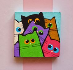 there are many different colored cats painted on this square piece of wood that looks like they's looking at the viewer