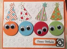 a birthday card with three different colored buttons and one has an eyeball on it