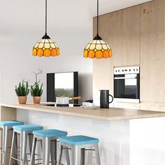 three lights hanging from the ceiling above a kitchen island with stools in front of it