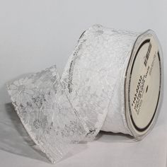 a roll of white lace ribbon sitting on top of a table