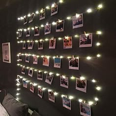 a wall with pictures and lights hanging on it's sides, along with photos pinned to the wall