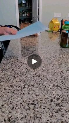 a counter top with a person holding a piece of paper