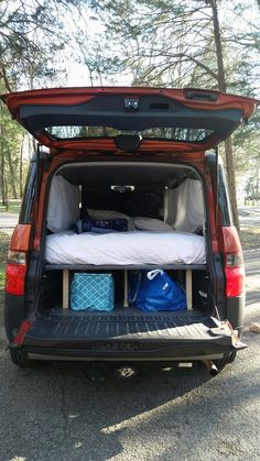 the back end of a van with its trunk open and luggage in it's cargo compartment