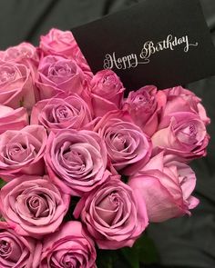 a bouquet of pink roses with a happy birthday card