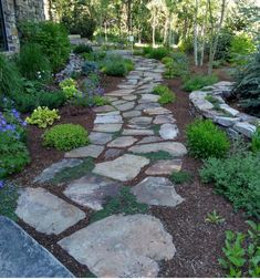 a stone path in the middle of a garden