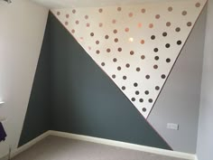 an empty room with polka dots painted on the wall and carpeted flooring in front of it