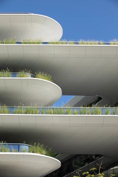 an architectural building with green plants growing on the balconies