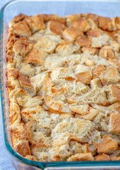 a casserole dish filled with bread cubes in a blue glass baking dish