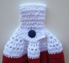 a knitted red and white mitt with a blue button