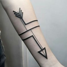 an arrow tattoo on the arm is shown in black and grey colors, with lines going through it