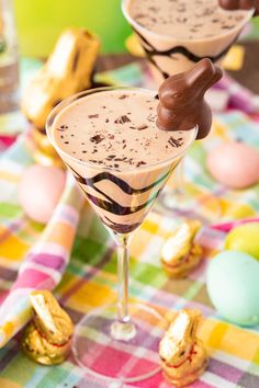 two glasses filled with chocolate and marshmallows on top of a checkered table cloth