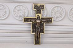 an ornate cross with a crucifix in the center on a white wall