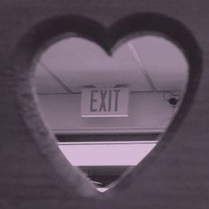 a heart shaped window with an exit sign in it