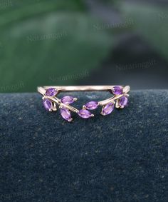 a close up view of a ring with purple stones on the front and back of it