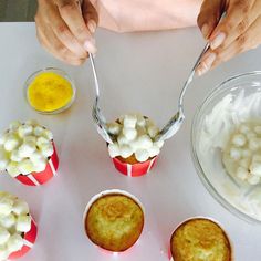 a table topped with cupcakes and muffins covered in white frosting