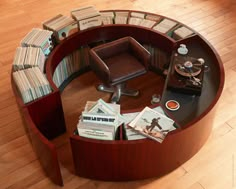 a round table with books and magazines on it in the middle of a wooden floor