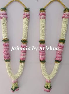 two pink and white flowers are attached to some string