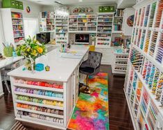 a room filled with lots of crafting supplies on shelves and floor to ceiling shelving