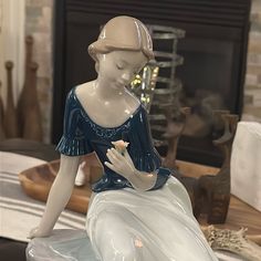 a ceramic figurine sitting on top of a table next to a fire place