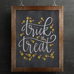 a chalkboard with the words trick or treat written on it and candy candies hanging from chains