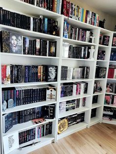 a bookshelf filled with lots of books on top of wooden floors next to a wall